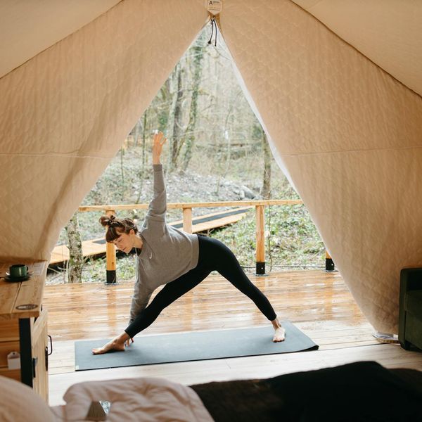 Person in a dynamic flowing yoga sequence, surrounded by soft light.